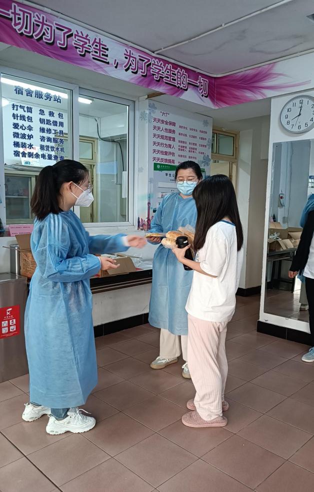 商务经济学院专职辅导员邹亚妮和王宇佳为在校学生配送餐食